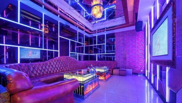 A modern lounge area with a leather sofa, a glass coffee table, and a chandelier. - Costa Resort（Xiachuan Island） (Taishan)