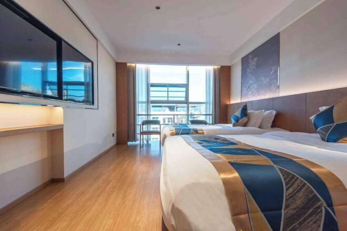Une chambre d’hôtel dotée d’un grand lit, d’une télévision à écran plat, d’une fenêtre avec vue et d’un coin repas.