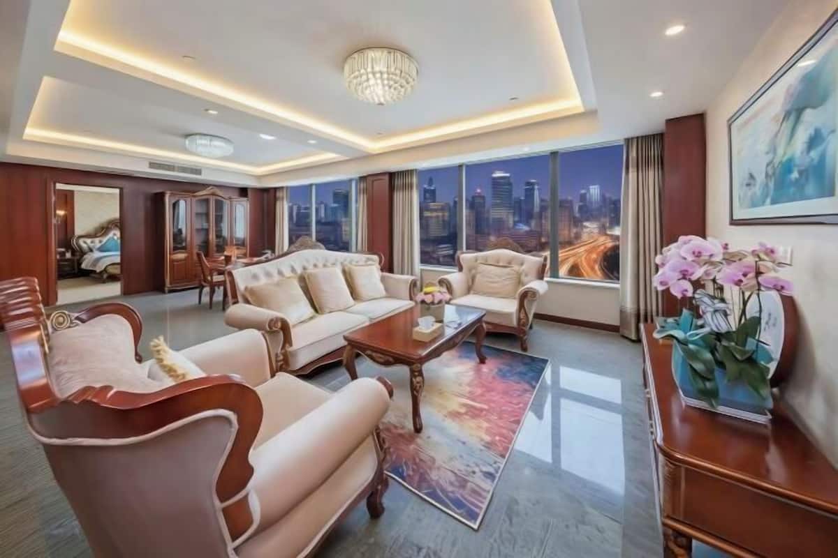 Amplio salón con vista a la ciudad, un candelabro y un ventanal grande.