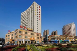 Un hôtel à plusieurs étages doté d’une cour intérieure, entouré d’autres bâtiments.