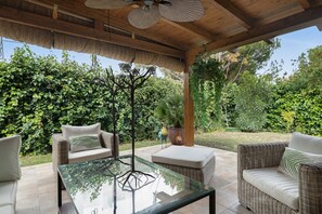 An outdoor patio with wicker furniture, a glass-top table, and a ceiling fan. - Cottage 'Rocio' with Private Terrace, Wi-Fi and Air Conditioning (El Puerto de Santa María)