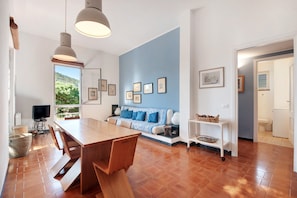 Un intérieur moderne comprenant un coin repas, un canapé et des œuvres d’art accrochées aux murs.