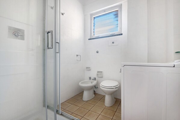 A bathroom with a glass shower enclosure, a bidet, a toilet, and a window. - Apartment 'Aurea' with Sea View, Balcony and Wi-Fi (Bonassola)