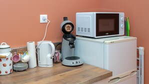 A kitchenette with a microwave, kettle, and coffee maker.