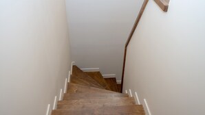 A wooden staircase with white trim and a handrail.