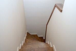 A wooden staircase with white trim and a handrail.
