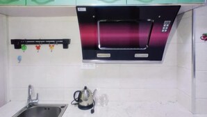 A kitchen with a stainless steel sink, a kettle, and a microwave oven. - Youth Apartments (Bilberry Manor, Yichun) (Yichun)