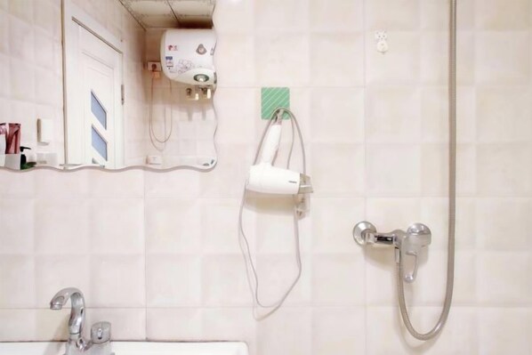 A bathroom with a shower, a sink, and a mirror.