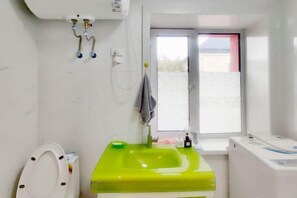 A bathroom with a green sink, a toilet, a window, and a washing machine. - Youth Apartments (Bilberry Manor, Yichun) (Yichun)
