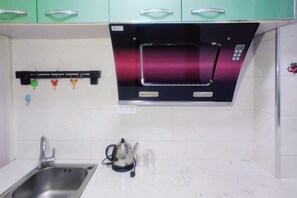 A kitchen with a built-in microwave, stainless steel sink, and a kettle. - Youth Apartments (Bilberry Manor, Yichun) (Yichun)