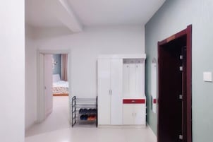 Un pasillo con un armario, un zapatero y una puerta que da a otra habitación.