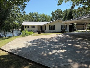 A single-story house with a covered porch, a concrete driveway, and a small lawn area. - Ketchum Cove Family & Pet-Friendly Lake House w/ Dock & Walk to Marina Dining (Vinita)