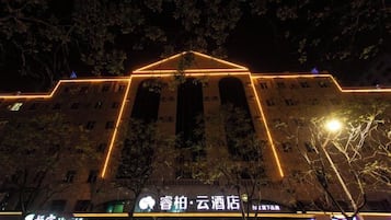 Un edificio con una entrada destacada y señalización iluminada.