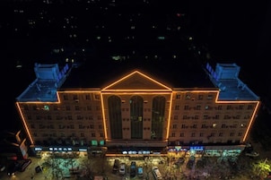 Un edificio grande con fachada simétrica, varias ventanas y una entrada central.