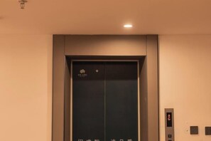 An elevator with a digital display and a control panel on the wall. - Homeinn Ripple Yun Hotel (Longkou North Street) (Longkou)