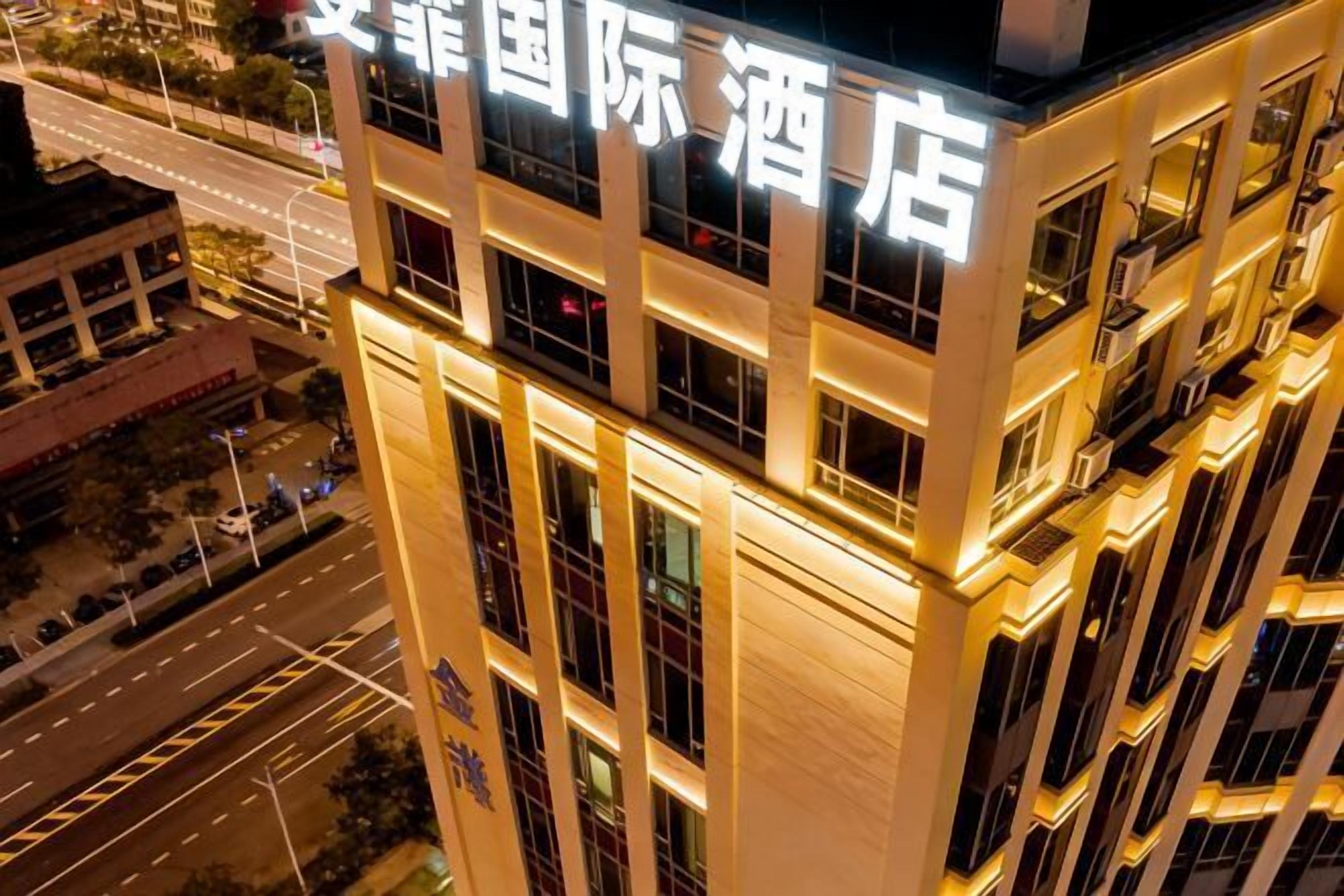Un bâtiment d’hôtel doté d’une enseigne lumineuse dans une langue étrangère, de plusieurs étages et d’une architecture moderne.