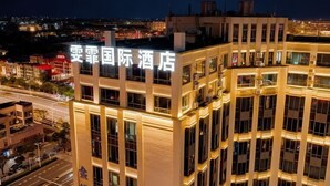 A hotel with multiple floors, large windows, and a prominent sign with Chinese characters. - Shanghai Wenfei Boutique Hotel (Shanghai)