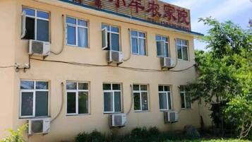 A building with multiple windows and air conditioning units, featuring a sign with Chinese characters.