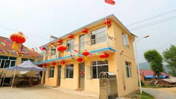 A two-story building with a balcony, a flag, and red lanterns.
