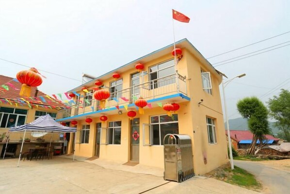 A two-story building with a balcony, a flag, and red lanterns.