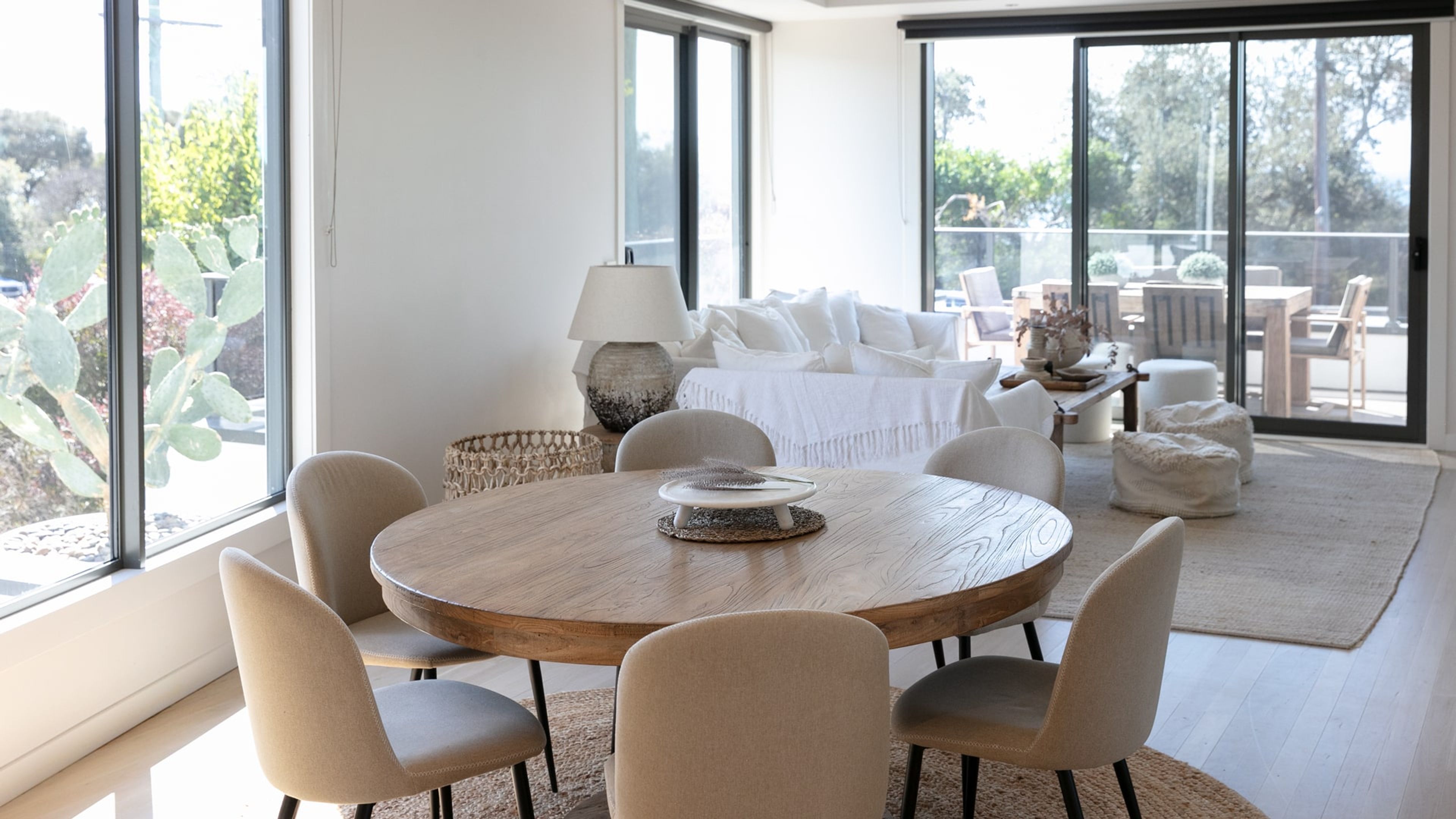 Un espace repas moderne avec une table ronde en bois, six chaises et un élément décoratif central.