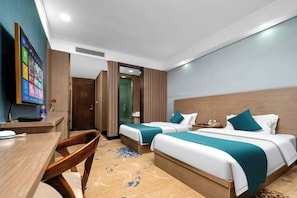 Una habitación de hotel con dos camas, un escritorio y un televisor.