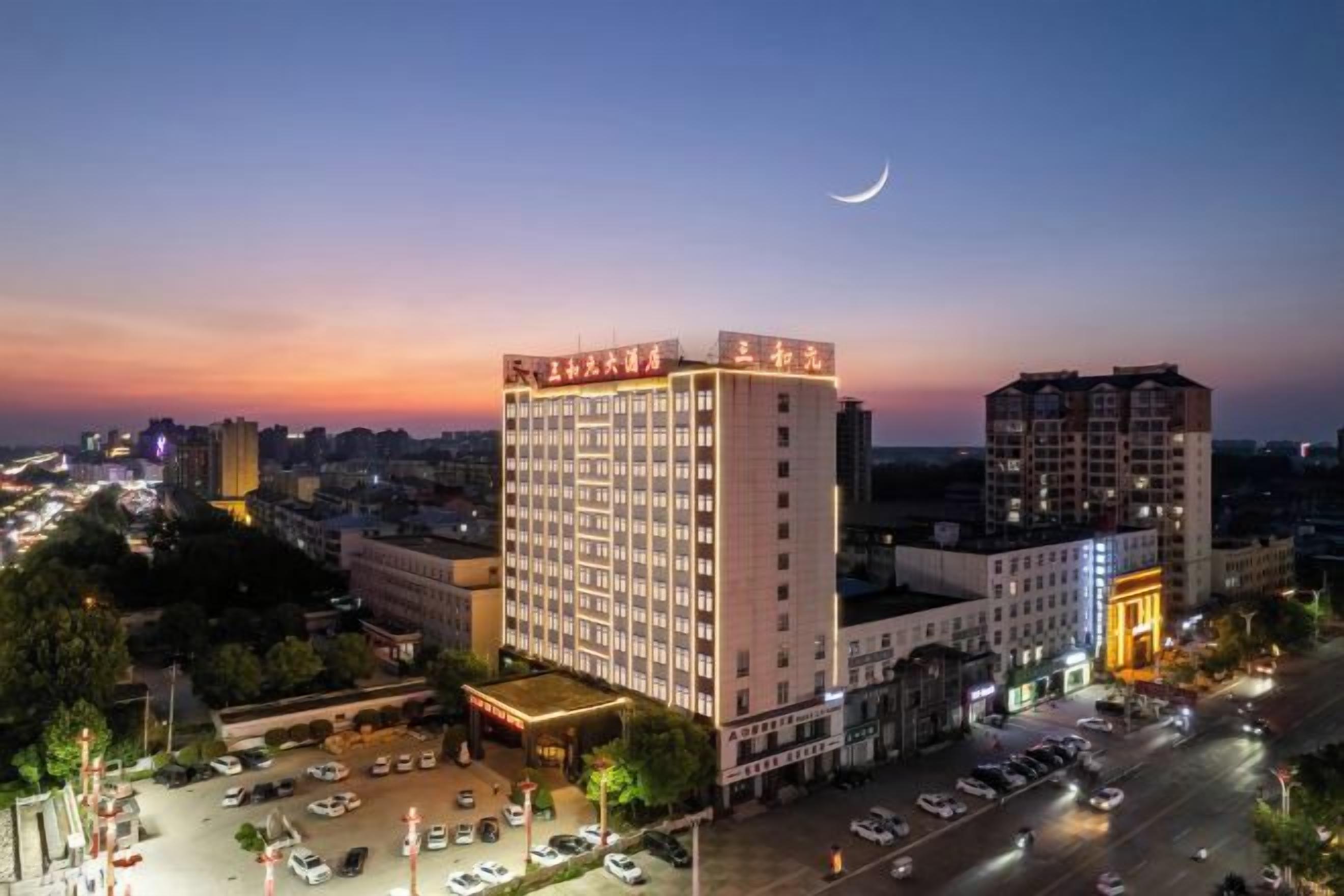 A multi-story hotel with a prominent entrance and a parking area.