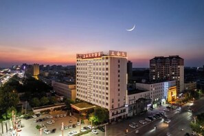 A multi-story hotel with a prominent entrance and a parking area. - Sanheyuan Hotel (Zhecheng Future Avenue Branch) (Zhecheng)