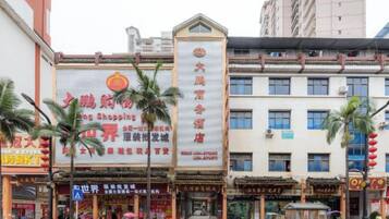A commercial building with multiple storefronts, including a prominent sign for a shopping mall.