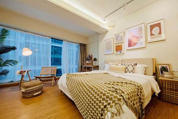 A hotel room with a large bed, a desk, a chair, and a view of the outdoors. - Libo Dapeng Business Hotel (Libo Ancient Town) (Libo)