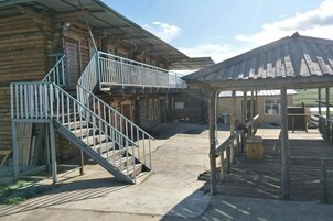 Ein Holzgebäude mit einer Treppe, einem überdachten Außenbereich und einem Metallgeländer.