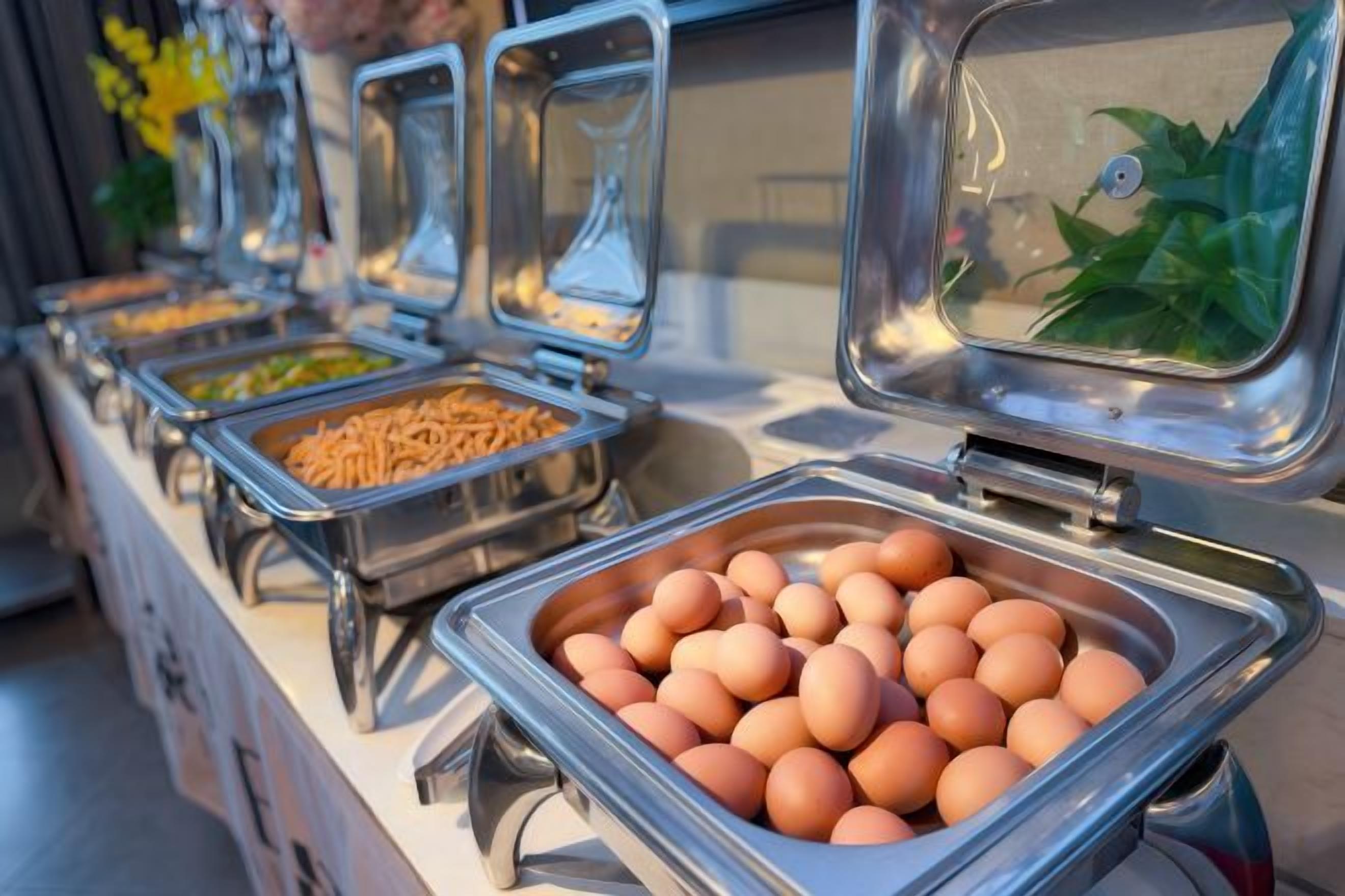 Un buffet proposant une variété de plats, notamment des œufs et d’autres aliments.