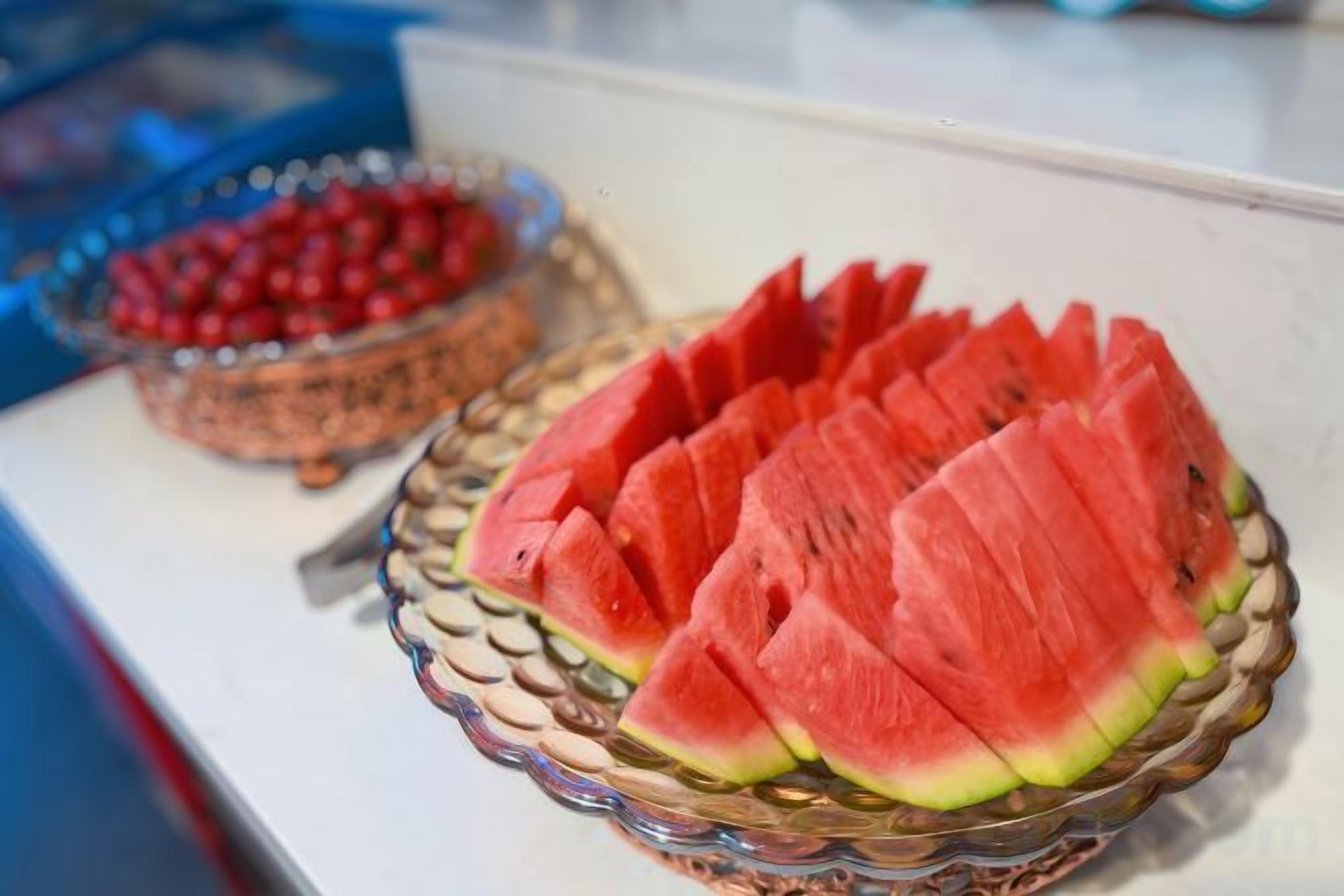 A glass bowl filled with watermelon slices on a table.