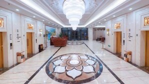 A hotel lobby with a marble floor, a large chandelier, and a modern design. - Mintai Hot Spring Holiday Hotel (Zibo)