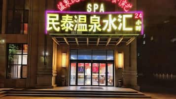 A building with a neon sign indicating a spa and a 24-hour service.