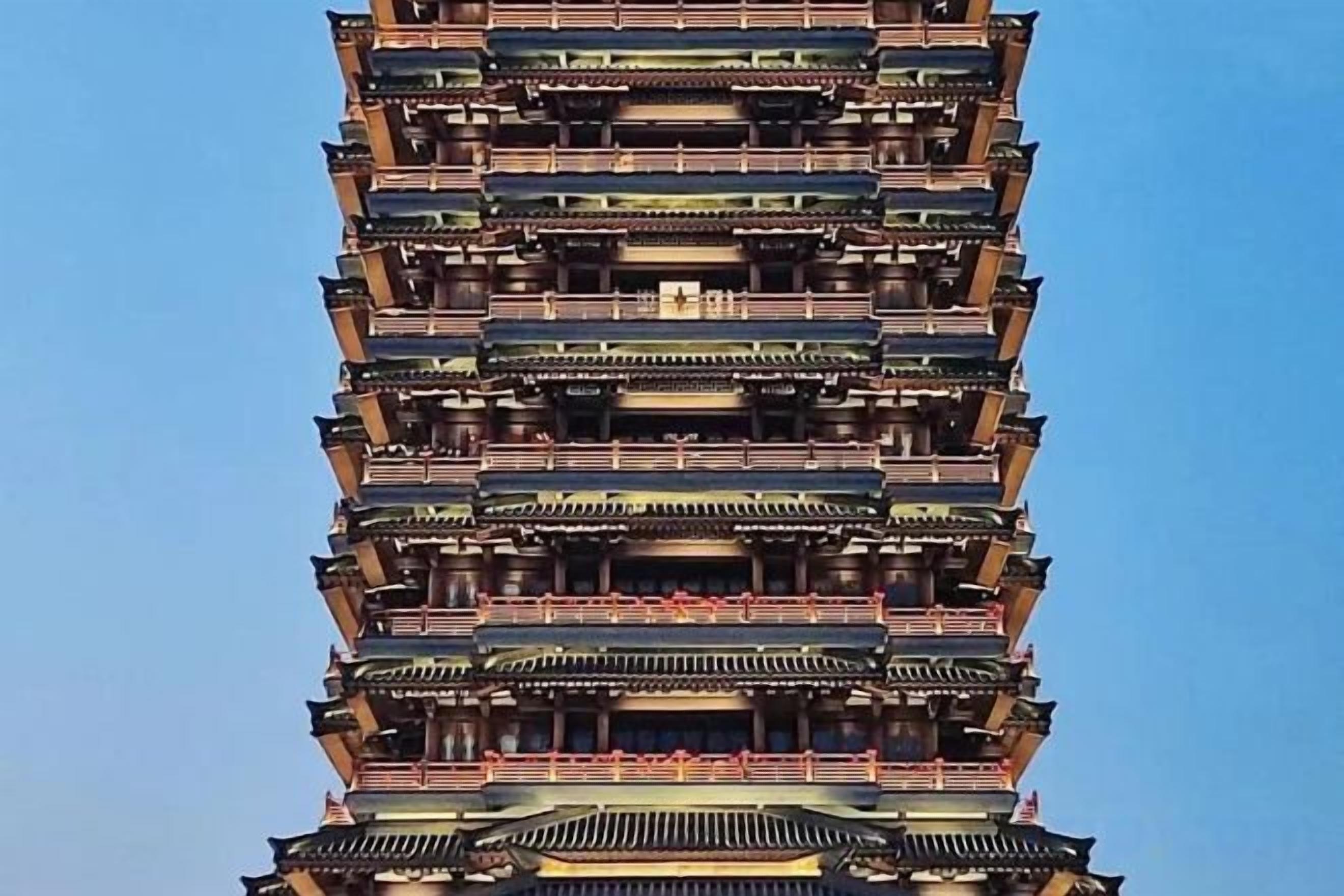 A multi-story building with a traditional architectural style, featuring numerous balconies and a clear sky in the background.