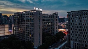 Un immeuble de grande hauteur, composé de plusieurs étages, et surmonté d’une enseigne bien visible.