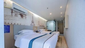 Une chambre d’hôtel avec deux lits, un grand miroir et un mur orné de plans architecturaux.