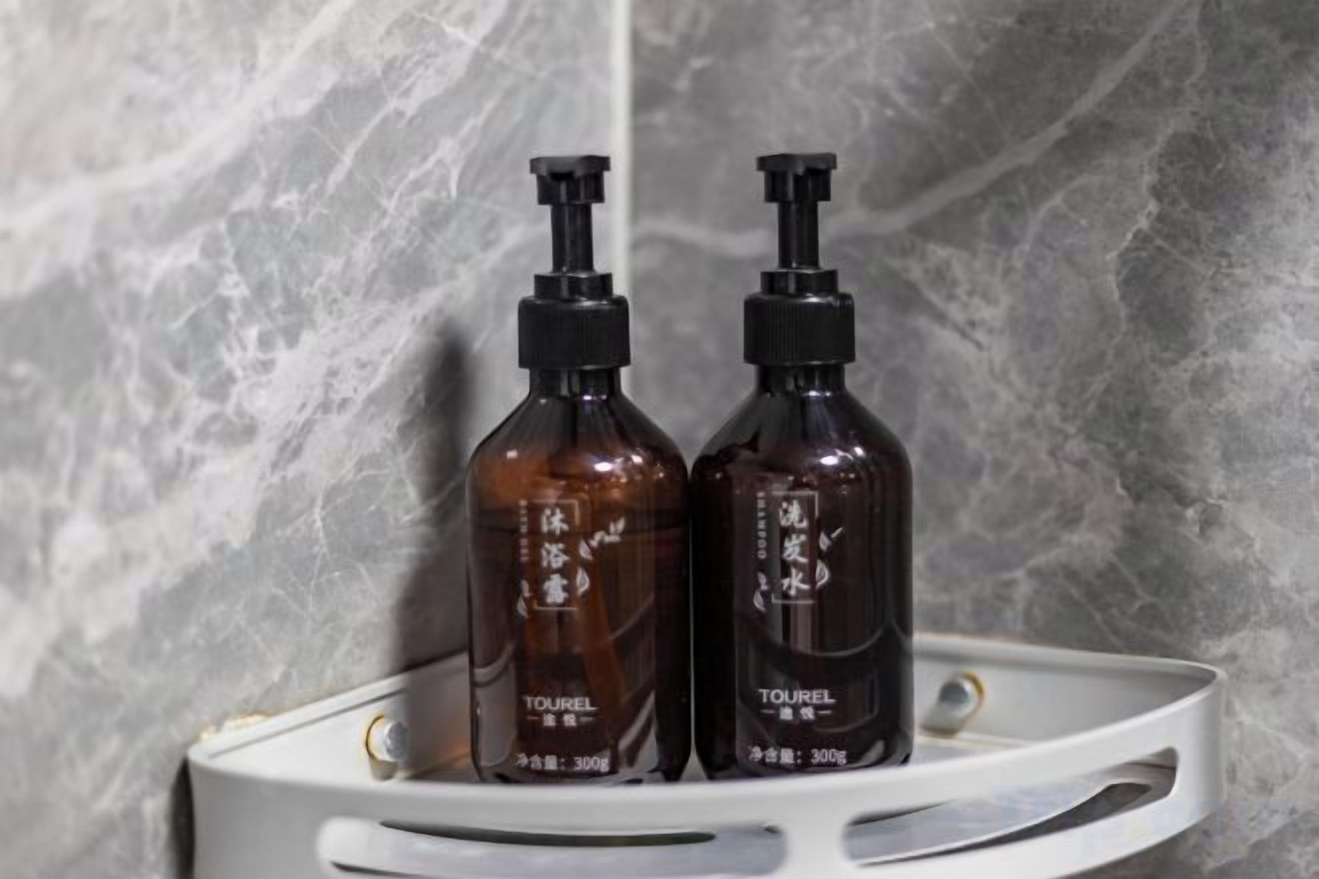 Two bottles of Tourel on a white tray against a marble wall.