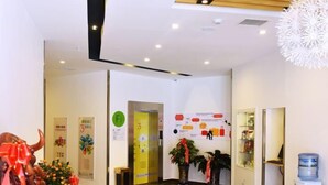A reception area with a wooden ceiling, a water dispenser, and a bulletin board with notices. - Homeinn Pebble Hotel (Hami Railway Station Bayi North Road) (Hami)