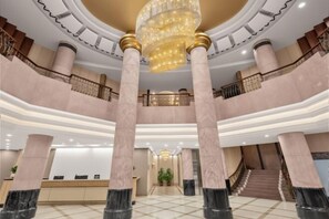 A spacious lobby with marble columns, a grand chandelier, and a reception desk. - YOUNG KING HOTEL(Foshan Nanhai Jiujiang Branch) (Foshan)