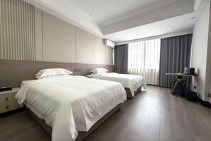 A hotel room with two beds, a bedside table, a desk, and a window with curtains. - YOUNG KING HOTEL(Foshan Nanhai Jiujiang Branch) (Foshan)