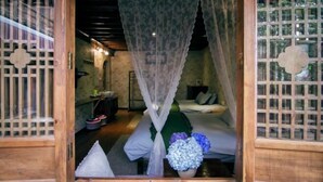 A traditional Japanese-style room with a bed, a wooden sliding door, and a decorative screen.