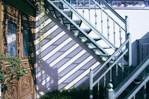A staircase with metal railings and a patterned floor, leading to an upper level. - Mrs. Sha's Living Room Inn (Jianchuan)