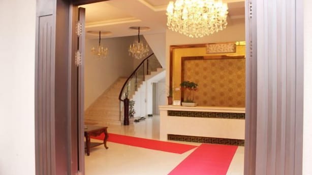 A reception area with a red carpet, a staircase, and a chandelier. - Peach blossom island bay longines farmhouse (Zhoushan)