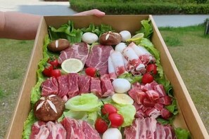 A wooden box filled with various meats, eggs, and vegetables. - Qihupan Inn Heping (Wuxi)
