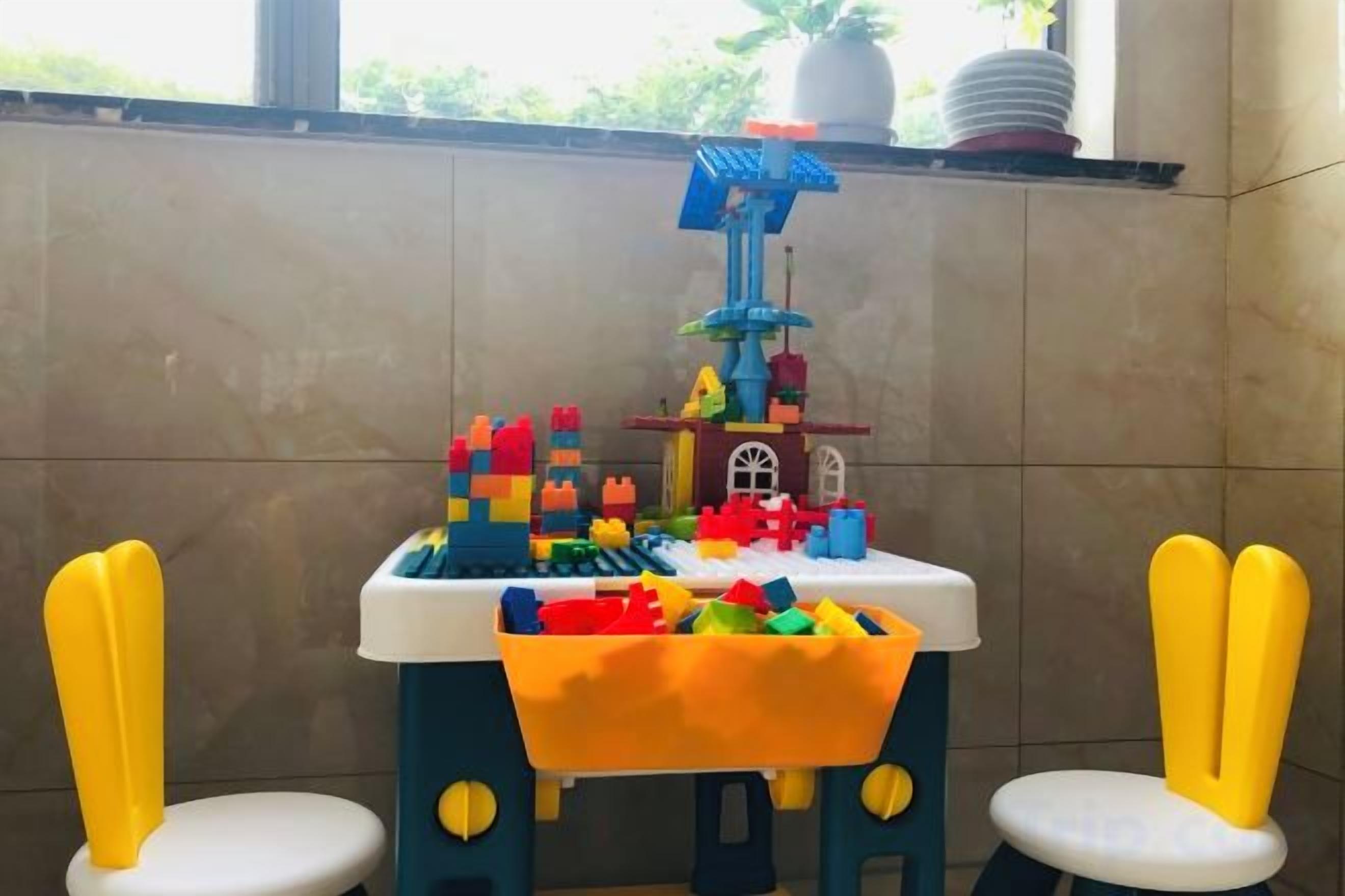 A play area with a colorful building structure and two yellow chairs.