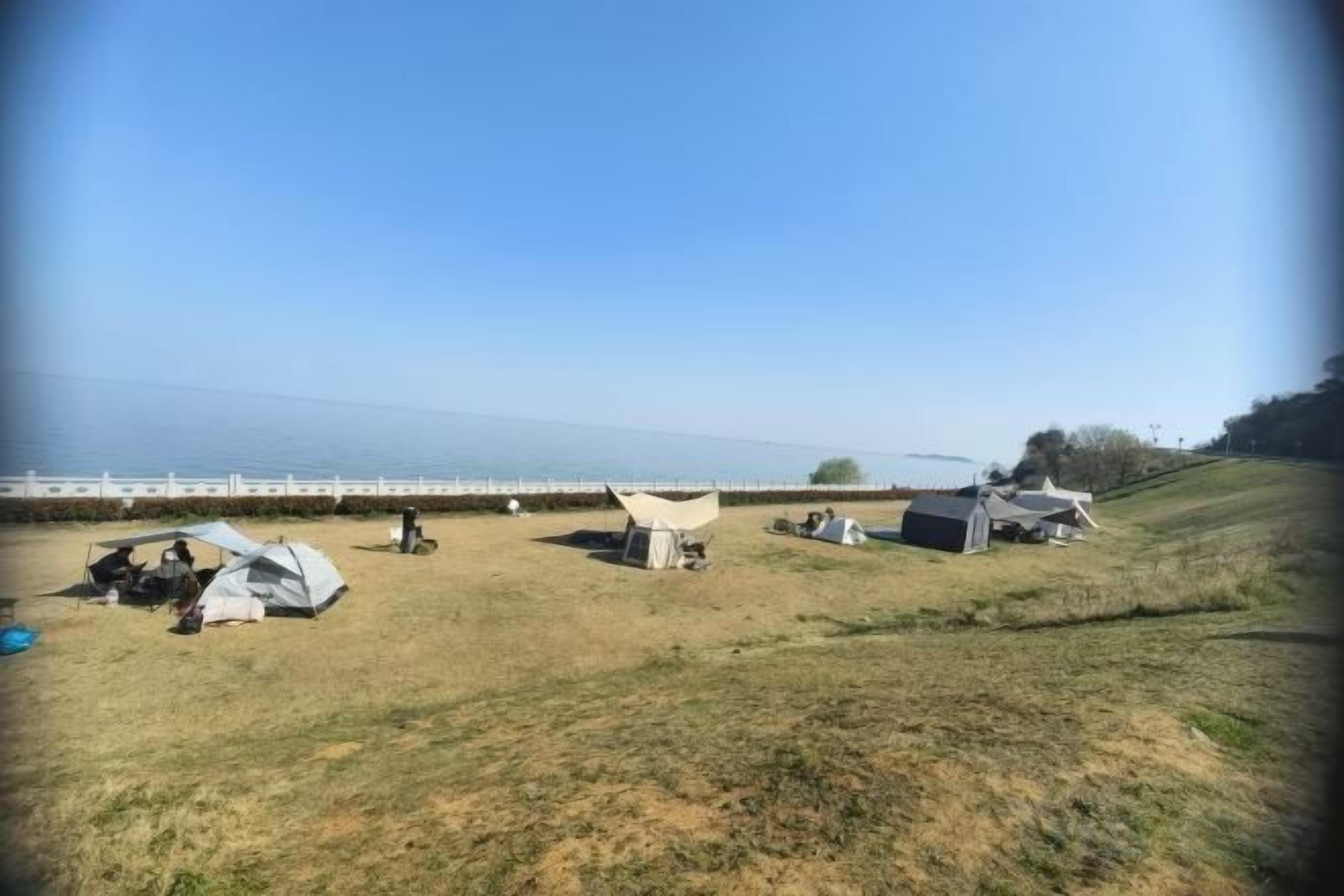 Ein Campingplatz mit Zelten und freiem Blick auf das Wasser.
