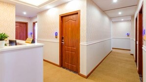 A hotel hallway with a reception desk, wooden doors, and a carpeted floor. - Lexiang. Smart Audio-Visual Boutique Stay (Changle International Airport) (Fuzhou)