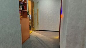 A narrow hallway with a carpeted floor, wooden cabinets on the left, and a glass door at the end. - Lexiang. Smart Audio-Visual Boutique Stay (Changle International Airport) (Fuzhou)
